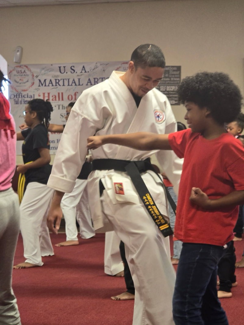 An instructor correcting a student's punching form.